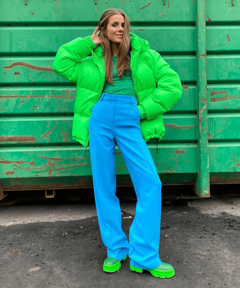 Mulher com look estilo moda dopamina, com cor verde e azul vibrantes. 